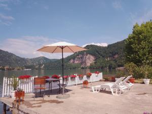 a patio with a table and chairs and an umbrella at Jezero in Potokovići +38 photos