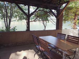 a wooden table and chairs with a view of the water at Jezero in Potokovići