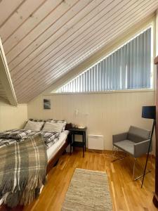a bedroom with a bed and a window and a chair at Alpintunet Uvdal in Sønstebø