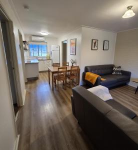a living room with a couch and a table at Restaway Holiday Units in Porepunkah +22 photos