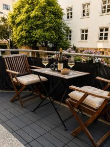 ein Tisch mit zwei Stühlen und einer Flasche Wein in der Unterkunft NOVA Living, Balkon, Nähe Altstadt & kostenlose Tiefgarage in Würzburg