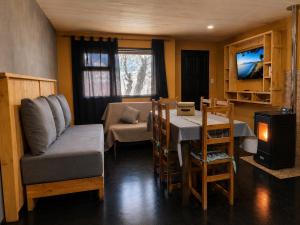 a living room with a table and a dining room at Tierras Mágicas in Villa Pehuenia