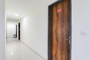 a wooden door with a sign on it in a hallway at Hotel O Manglam Hotel in Chinhat