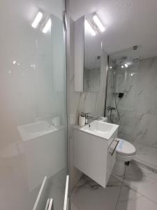 a white bathroom with a sink and a toilet at Anris & Dianas Dom - In a quiet part of the center in Kallithea Halkidikis +58 photos
