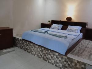 a bedroom with a large bed with blue sheets at Galuh Hostel Lombok in Pawenang +16 photos
