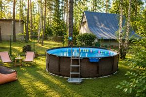 a hot tub with a ladder in a yard at Dom w lesie - Schodno13 in Schodno