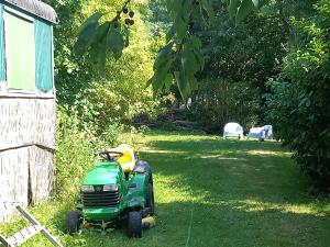 a green lawn mower parked in a yard at Toplocatie voor je workshop! Of grote gezin! Zwembad! in Hurwenen +24 photos
