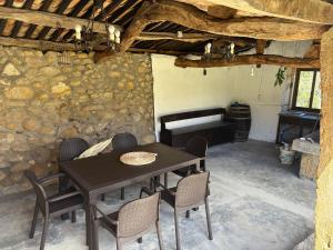 a table and chairs in a room with a stone wall at Casa de Gándara in Baiona