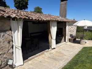 a patio with an umbrella and a table and chairs at Casa de Gándara in Baiona