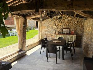 a patio with a table and chairs in a stone wall at Casa de Gándara in Baiona