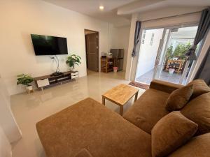 a living room with a couch and a flat screen tv at CheeVa Beach Resort in Ban Tai