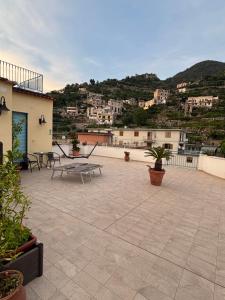 a patio with tables and chairs on top of a building at Le Suites di Teodoro in Maiori
