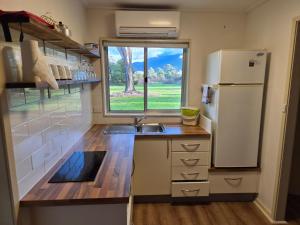 a small kitchen with a sink and a refrigerator at Restaway Holiday Units in Porepunkah
