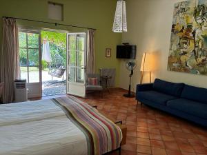 a bedroom with a bed and a blue couch at Hotel Le Moulin du Château in Saint-Laurent-du-Verdon