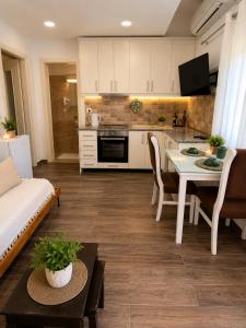 a kitchen and a living room with a table at Apartament Drasa in Gjirokastër