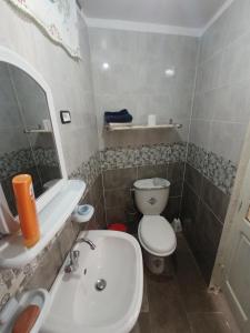 a bathroom with a white sink and a toilet at Maison Kram Plage in Le Kram