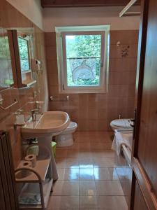 a bathroom with a sink and a toilet and a window at Appartamenti Bice Abetone in Abetone +41 photos