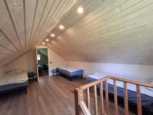 a room with two beds and a wooden ceiling at Riverside Sauna House in Savala