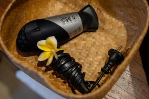 a bottle of wine in a straw hat with a flower at KERAMAN SUITE UBUD in Ubud