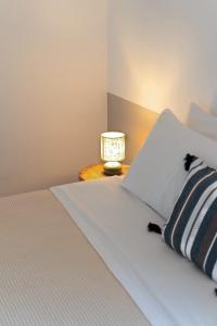 a bedroom with a bed with a lamp on a table at Oliaros Seaside Lodge in Agios Georgios
