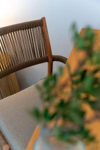 a table and a chair with a table and a plant at Oliaros Seaside Lodge in Agios Georgios