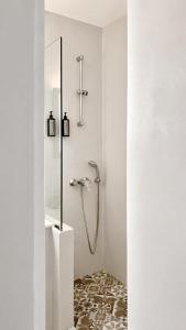 a bathroom with a shower in a white room at Oliaros Seaside Lodge in Agios Georgios