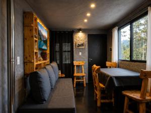 a room with a bed and a table and a window at Tierras Mágicas in Villa Pehuenia