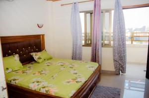 a bedroom with a bed with a green comforter at Raoul Immobilier JDMK in Brazzaville