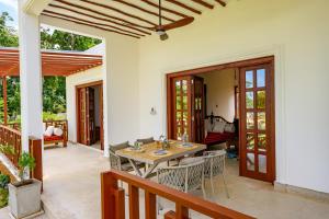 a dining room with a table and chairs on a patio at Kasa Pomboo Hotel, Shimoni in Shimoni