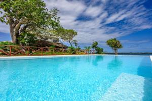 a large swimming pool with blue water at Kasa Pomboo Hotel, Shimoni in Shimoni