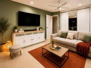 a living room with a couch and a flat screen tv at The Sanctuary on William - Nature Reserve Hideaway in Ormiston
