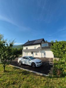 a car parked in a parking lot in front of a house at Lika Relax and Party House with sauna, jacuzzi and outdoor heated swimming pool in Lovinac