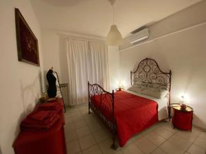 a bedroom with a red bed and a red blanket at Casa Rosso Melograno in Alassio