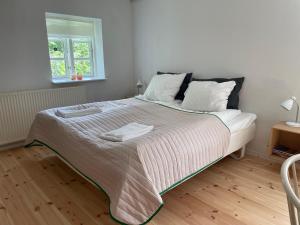a bedroom with a large bed with two towels on it at Davinde Gæstgiveri in Odense