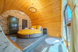 a bed in a room with a wooden ceiling at Qafqaz Rolling Bungalow in Gabala +119 photos