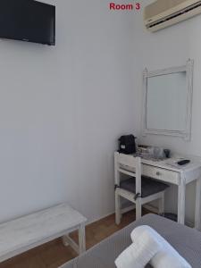 a white room with a desk and a mirror at Sunset Hotel Kini Beachside in Kini