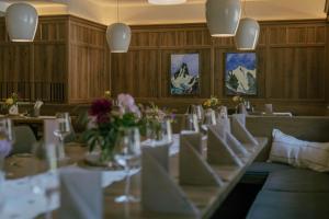 a dining room with a table with chairs and flowers at Hotel Metzgerwirt in Sankt Veit im Pongau