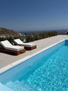 a swimming pool with two lounge chairs next to it at Elia Horizon Mykonos in Elia Beach