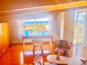 a living room with a table and a large window at Asclepeias Ionian Villa in Argassi