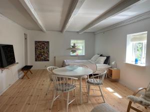 a living room with a table and chairs and a bed at Davinde Gæstgiveri in Odense