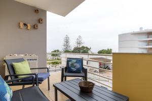 a balcony with chairs and a table and a view at Ria Olhao in Olhão