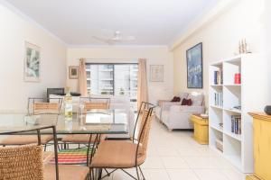 a dining room and living room with a table and chairs at Ria Olhao in Olhão