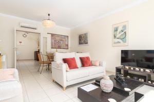 a living room with a white couch and a tv at Ria Olhao in Olhão
