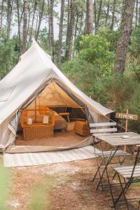 ein Zelt mit Stühlen und einem Tisch in einem Wald in der Unterkunft Cocooning Tipi - Seignosse in Seignosse