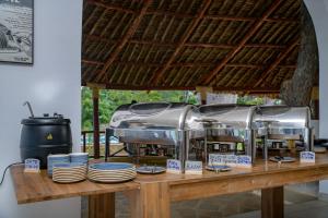 a table with plates and silver dishes on it at Kasa Pomboo Hotel, Shimoni in Shimoni