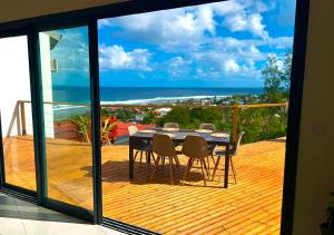 a dining table on a deck with a view of the ocean at La Villa Bleu Lagon in Petite Île +20 photos
