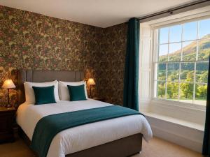 a bedroom with a large bed and a window at Scale Hill Hotel in Loweswater