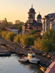 a couple of boats in the water in front of a building at Căsuța Sofia in Sulina
