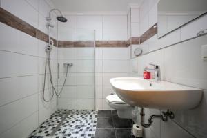 a bathroom with a sink and a toilet at Hotel Mykonos in Eschweiler