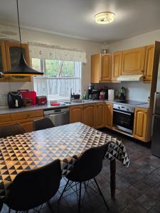 a kitchen with a table and chairs and a kitchen with a stove at Kríukot íbúð in Hólmavík